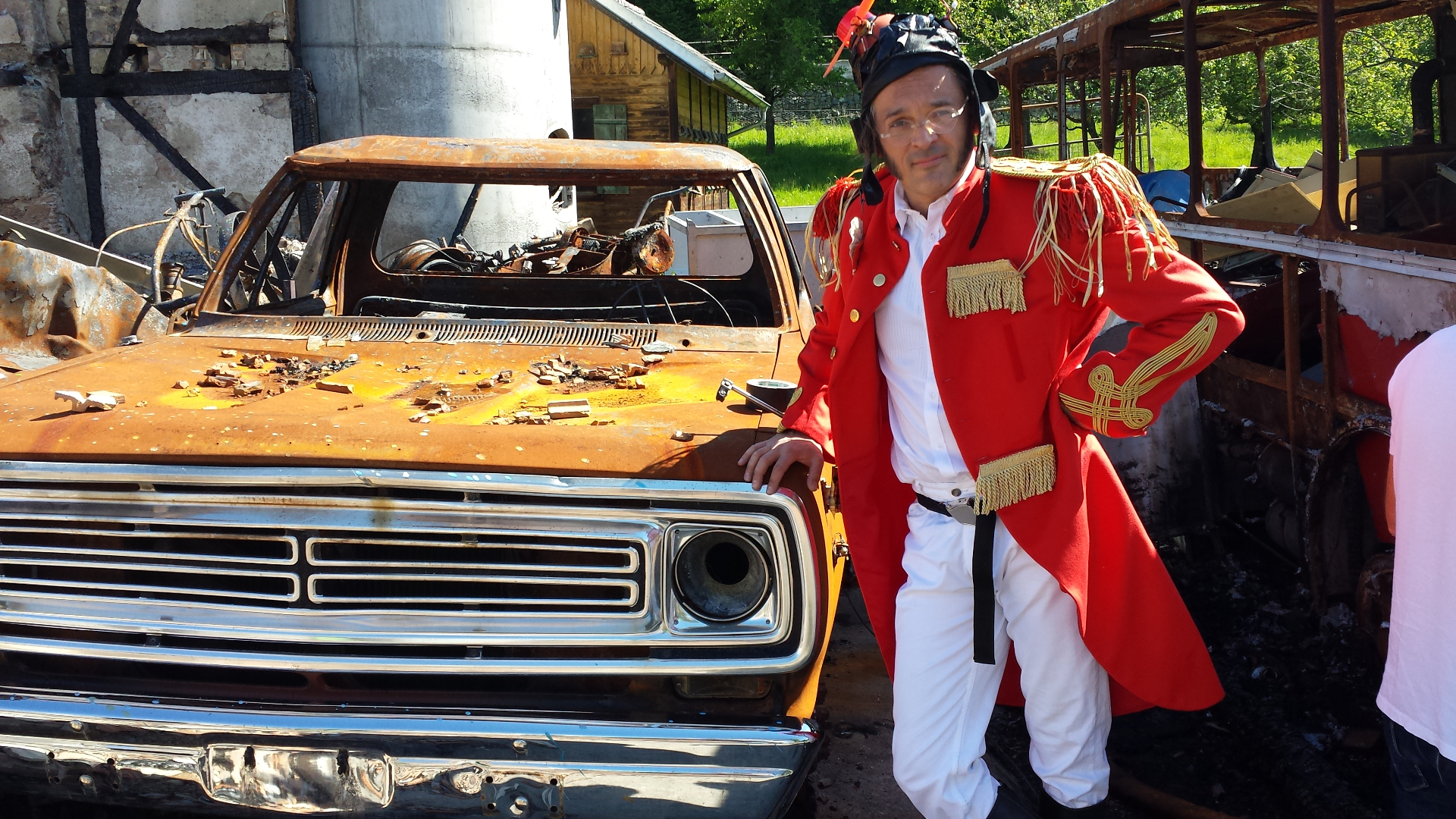 Superbuffo im roten Uniform-Mantel neben rostigem Pickup